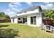 Backyard featuring a covered patio with outdoor seating, a manicured lawn and white exterior walls at 2536 Brookshire Ave, Winter Park, FL 32792