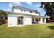 A backyard featuring a covered patio with outdoor seating, a manicured lawn and white exterior walls at 2536 Brookshire Ave, Winter Park, FL 32792