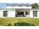 A serene backyard featuring a covered patio, lush lawn, and bright white exterior walls at 2536 Brookshire Ave, Winter Park, FL 32792