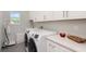 Bright laundry room with white cabinets, modern appliances, and plenty of counter space at 2536 Brookshire Ave, Winter Park, FL 32792