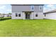 Spacious backyard with green grass and a two-story home, perfect for outdoor activities at 2933 Wild Olive Dr, St Cloud, FL 34772