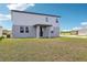 A two-story gray home with a well-manicured backyard and sliding glass door at 2933 Wild Olive Dr, St Cloud, FL 34772