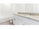 Bright bathroom featuring a granite-topped vanity, tub, and toilet at 2933 Wild Olive Dr, St Cloud, FL 34772