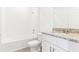 Bright bathroom featuring white cabinets, a granite countertop, and a shower over tub with white tile surround at 2933 Wild Olive Dr, St Cloud, FL 34772