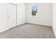 Bright bedroom with carpet flooring, a window overlooking the yard, and a closet with sliding doors at 2933 Wild Olive Dr, St Cloud, FL 34772