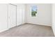Bright bedroom with carpet flooring, a window overlooking the yard, and a closet with sliding doors at 2933 Wild Olive Dr, St Cloud, FL 34772