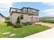 A gray two-story home with green lawn and a brick driveway and sidewalk at 2933 Wild Olive Dr, St Cloud, FL 34772