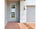 Close-up of a modern front door and garage with a brick walkway and exterior lighting at 2933 Wild Olive Dr, St Cloud, FL 34772