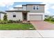 Modern two-story home featuring a brick driveway, well-kept lawn, and neutral siding at 2933 Wild Olive Dr, St Cloud, FL 34772