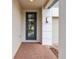 Stylish home entrance with a blue front door, brick pathway, and modern lighting fixture at 2933 Wild Olive Dr, St Cloud, FL 34772