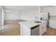 Open-concept kitchen with a stainless steel refrigerator, island sink, and view into the living area at 2933 Wild Olive Dr, St Cloud, FL 34772