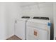 Laundry room features new white washer and dryer on hardwood-style floors at 2933 Wild Olive Dr, St Cloud, FL 34772