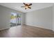 Bedroom with wood floors, ceiling fan, and sliding glass doors to the backyard at 3275 Deer Lick Ct, Kissimmee, FL 34746