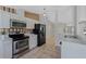 Well-equipped kitchen featuring stainless steel appliances, white cabinetry, and stylish wallpaper accents at 3275 Deer Lick Ct, Kissimmee, FL 34746