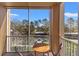 Cozy balcony featuring a round table and chairs with a view of the parking area and trees at 3332 Robert Trent Jones Dr # 20703, Orlando, FL 32835