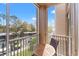 Relaxing balcony with a round table and chairs overlooking a parking area with mature trees at 3332 Robert Trent Jones Dr # 20703, Orlando, FL 32835