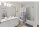 Well-lit bathroom featuring a vanity, toilet, and a shower-tub combo with gray striped shower curtain at 3332 Robert Trent Jones Dr # 20703, Orlando, FL 32835