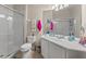 Bright bathroom featuring a shower, toilet, and white vanity with a mirror and overhead lighting at 3332 Robert Trent Jones Dr # 20703, Orlando, FL 32835