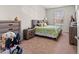 Well-lit bedroom with carpet floors, a window, and wood furniture at 3332 Robert Trent Jones Dr # 20703, Orlando, FL 32835