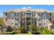 Multi-story condo building featuring balconies, neutral paint, dark shutters, and manicured landscaping at 3332 Robert Trent Jones Dr # 20703, Orlando, FL 32835