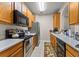 Kitchen with wood cabinets, appliances, rug, and view into other rooms at 3332 Robert Trent Jones Dr # 20703, Orlando, FL 32835