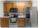 Kitchen with wood cabinets and stainless steel appliances at 3332 Robert Trent Jones Dr # 20703, Orlando, FL 32835