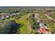Scenic aerial view of homes along a golf course and pond, surrounded by lush greenery and mature trees at 3352 Park Grove Ct, Longwood, FL 32779