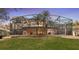 Beautiful backyard view of the screened-in lanai, grass, and trees at 3352 Park Grove Ct, Longwood, FL 32779