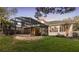 A beautifully landscaped backyard, featuring a screened-in pool area and lush green lawn at 3352 Park Grove Ct, Longwood, FL 32779