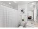 Well-lit bathroom with white fixtures, a framed mirror, and a shower with a curtain, creating a clean and functional space at 3352 Park Grove Ct, Longwood, FL 32779