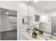 Bright bathroom featuring dual sinks, a large mirror, and a view into the adjacent room at 3352 Park Grove Ct, Longwood, FL 32779