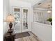 Welcoming entryway featuring double glass doors, light wood floors, and a decorative lamp and table at 3352 Park Grove Ct, Longwood, FL 32779