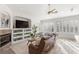 Inviting living room featuring a fireplace, built-in shelving, a ceiling fan, and large windows with light-filtering shutters at 3352 Park Grove Ct, Longwood, FL 32779
