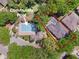 Aerial view of the community pool surrounded by mature trees, and the house to the right with a private pool at 3415 Starbird Dr, Ocoee, FL 34761