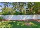 Fenced backyard featuring a lawn and lots of trees and plantings behind the white fence at 3415 Starbird Dr, Ocoee, FL 34761