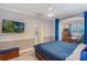 Comfortable bedroom with a large TV, desk, dresser, and a view of the outside at 3415 Starbird Dr, Ocoee, FL 34761