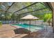Screened pool with an umbrella for shade, surrounded by brick pavers and lush landscaping at 3415 Starbird Dr, Ocoee, FL 34761
