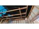 Extensive fire damage reveals exposed wood rafters and beams of the home's interior covered by a blue tarp at 4421 Steed Ter, Winter Park, FL 32792