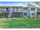 Townhome backyard featuring a screen porch, balcony, and well-manicured lawn at 5122 Cypress Creek Dr # 103, Orlando, FL 32811
