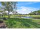 Scenic community view of a pond and fountain with well-maintained landscaping and blue skies at 5122 Cypress Creek Dr # 103, Orlando, FL 32811