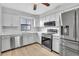 Modern kitchen boasts stainless steel appliances, white cabinetry, and updated countertops at 5122 Cypress Creek Dr # 103, Orlando, FL 32811
