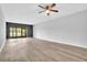 Spacious living room featuring wood-look floors, a ceiling fan, and bright natural light at 5122 Cypress Creek Dr # 103, Orlando, FL 32811