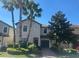 Charming two-story home with a manicured lawn, palm trees, and a private garage at 5520 Solterra Cir, Davenport, FL 33837