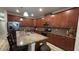 Spacious kitchen featuring stainless steel appliances, granite countertops, and wood cabinets at 5520 Solterra Cir, Davenport, FL 33837