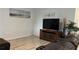 Open living room with wood floors, a modern TV stand, and neutral walls at 5520 Solterra Cir, Davenport, FL 33837