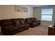 Inviting living room featuring plush seating, neutral walls, and seamless carpet flooring throughout at 5520 Solterra Cir, Davenport, FL 33837