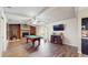 Open living room with brick fireplace, a billiard table, wood floor and white ceiling beams at 650 N 4Th Ave, Deltona, FL 32725