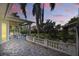 Covered back patio features a stone tile floor, white fence, and a peaceful, landscaped view at 703 Valencia Shores Dr, Winter Garden, FL 34787