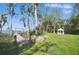 Lush backyard featuring a dock on the water, verdant lawn, trees, and a charming white gazebo at 703 Valencia Shores Dr, Winter Garden, FL 34787