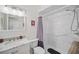 Clean bathroom with a single sink, toilet, and shower with purple-striped curtain at 703 Valencia Shores Dr, Winter Garden, FL 34787